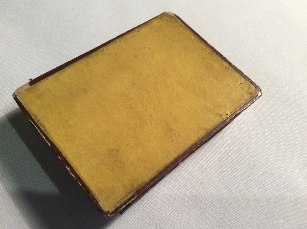 A rectangular 19th-century French bonbon box featuring gilded embossed paper borders and a glass inset lid depicting a miniature outdoor scene. View V