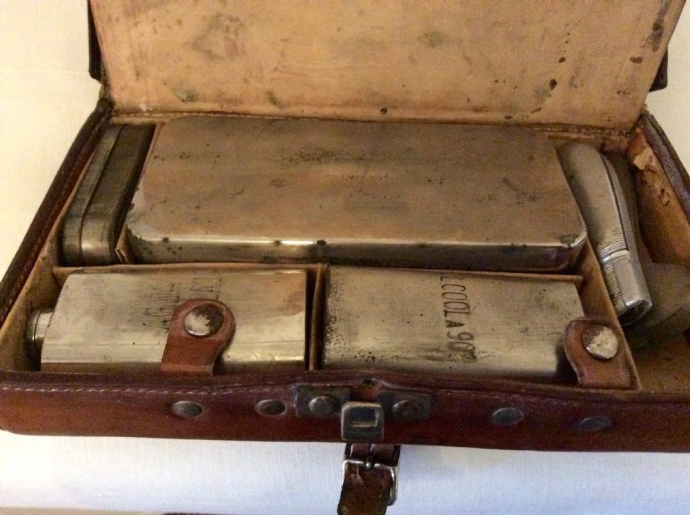 A rectangular warm brown leather veterinary field kit featuring a top carry handle, metal clasp closure, and a central leather buckle strap. View IX