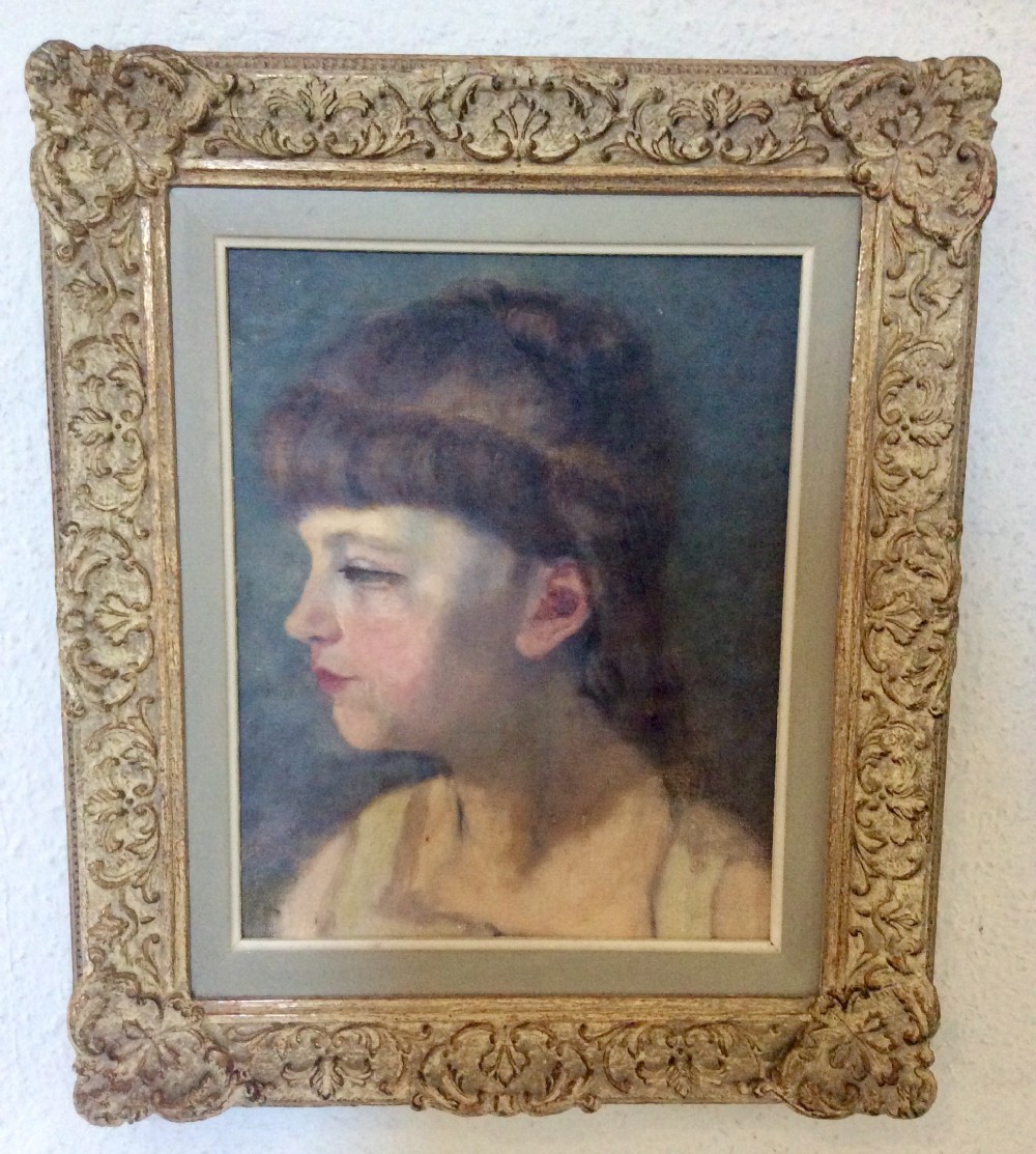 A profile portrait painting of a young French girl with fringe hair, presented in an ornate gilt scrollwork frame.