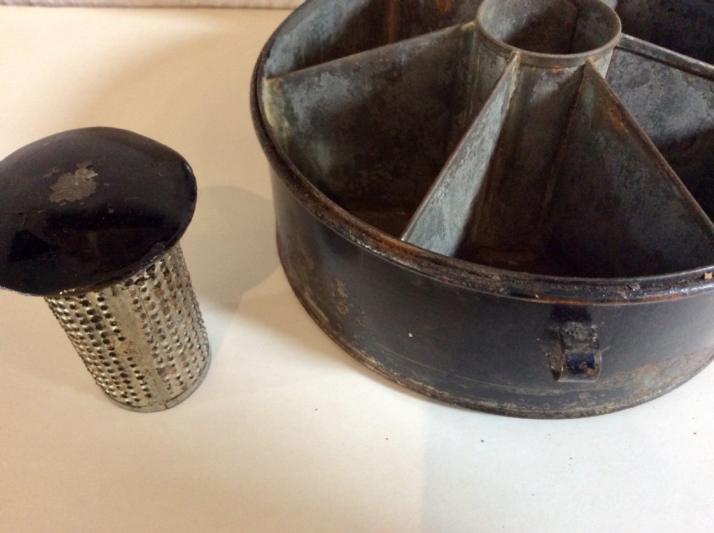 A circular black toleware spice box featuring a domed lid, brass top ring handle, gold accent band, and front metal latch. View VII