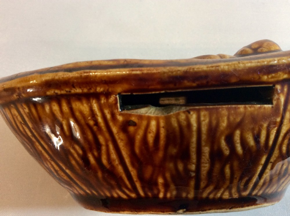 Rare treacle glaze French money bank in the form of a child in bed View III