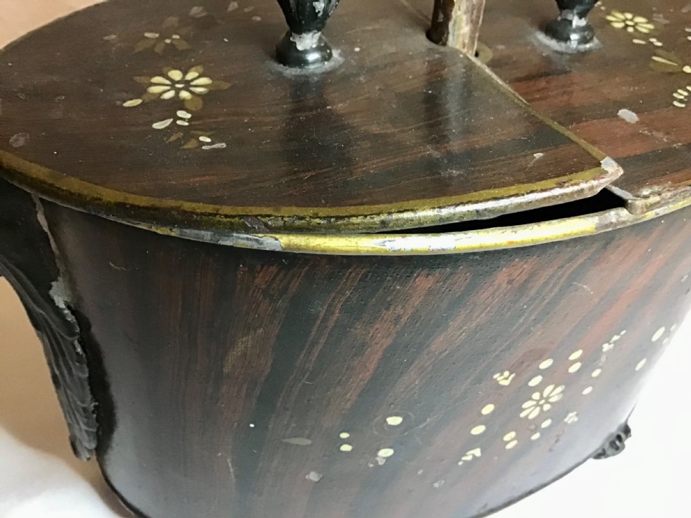 A dark brown oval wooden egg coddler featuring floral bone inlay, side handles, four metal feet, and three pinecone finials on the split lid. View III
