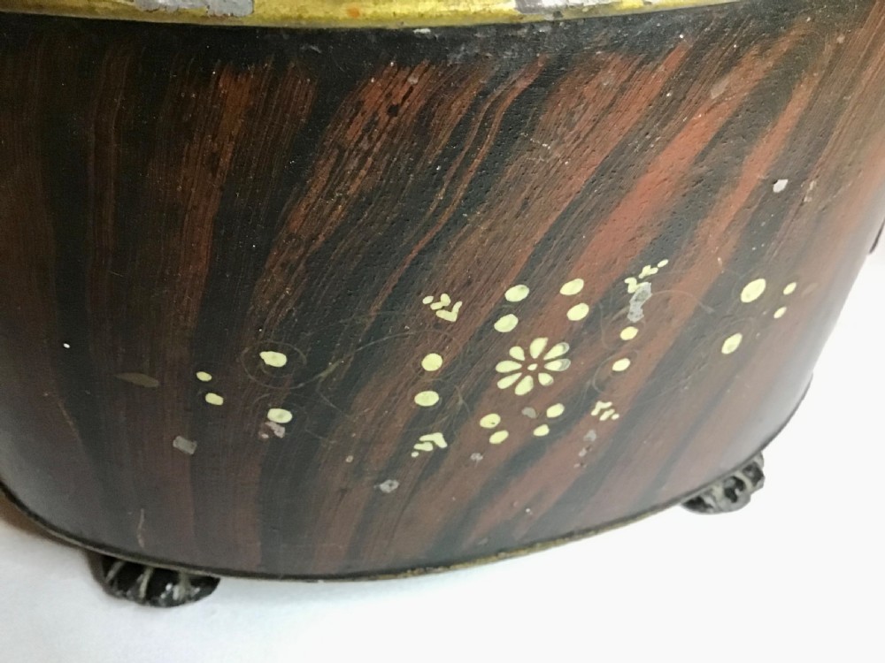 A dark brown oval wooden egg coddler featuring floral bone inlay, side handles, four metal feet, and three pinecone finials on the split lid. View V