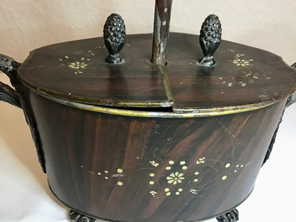 A dark brown oval wooden egg coddler featuring floral bone inlay, side handles, four metal feet, and three pinecone finials on the split lid. View XIII