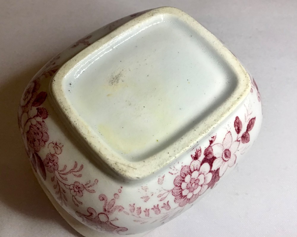 A small rectangular Victorian cream earthenware sugar bowl and fitted lid printed with a burgundy transferware floral pattern. View V