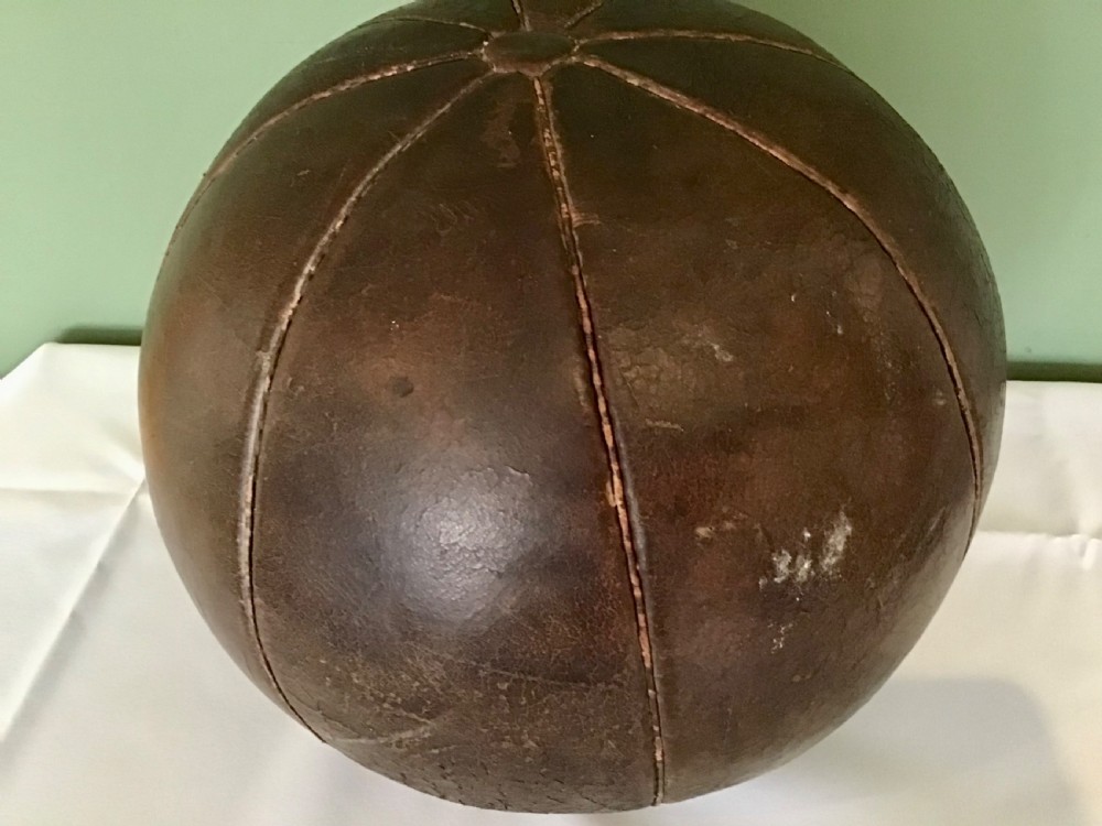 A spherical Edwardian medicine ball crafted from dark brown stitched leather panels displaying a weathered patina. View II