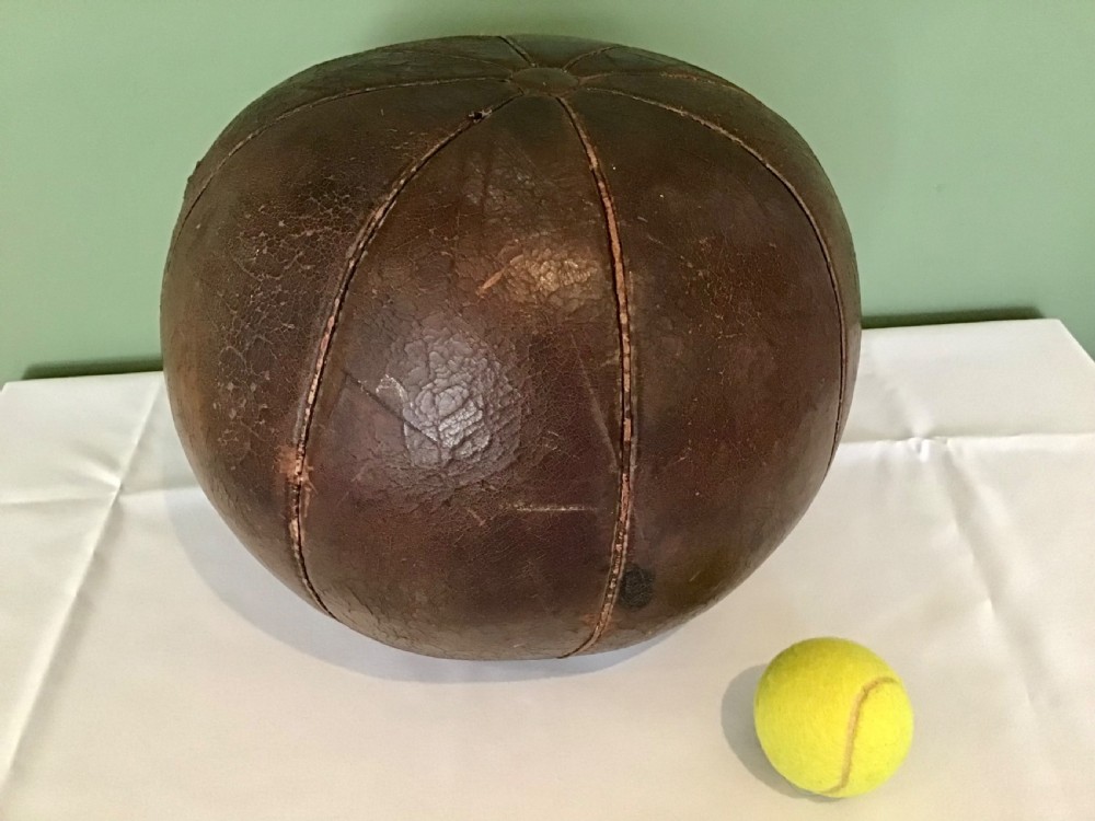 A spherical Edwardian medicine ball crafted from dark brown stitched leather panels displaying a weathered patina. View VI