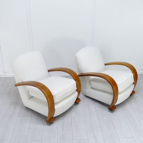 fig 3. A pair of 1930s Art Deco armchairs upholstered in cream textured fabric featuring sweeping bentwood wooden armrests and castors.