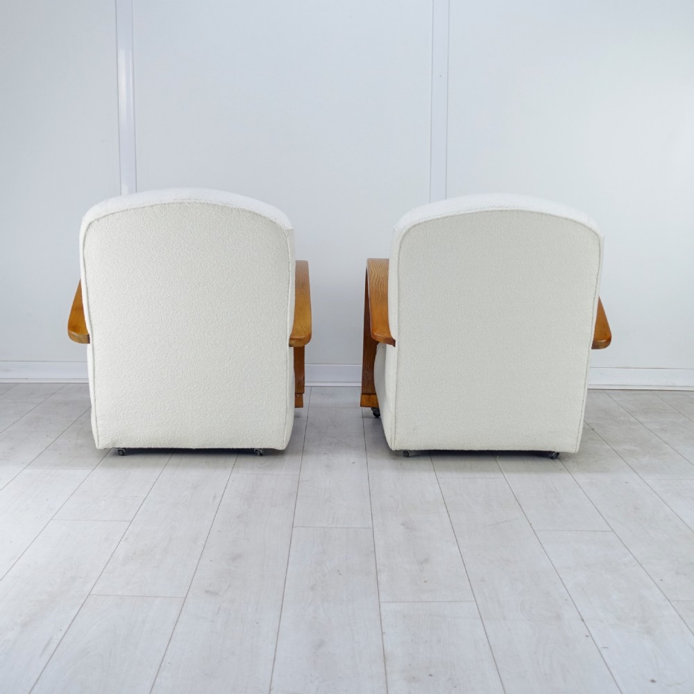 A pair of 1930s Art Deco armchairs upholstered in cream textured fabric featuring sweeping bentwood wooden armrests and castors. View VI