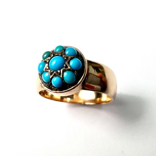 fig 1. A Victorian 18ct yellow gold ring featuring a central round panel set with turquoise cabochons forming an eight-pointed star motif.