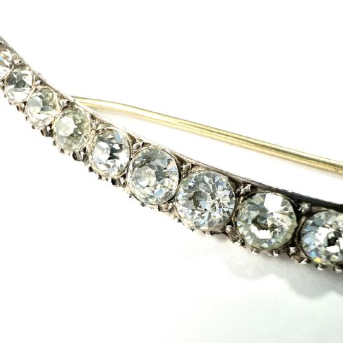 fig 1. A Victorian crescent moon brooch set with a single row of graduated clear paste stones in a silver setting with a long pin fastening.