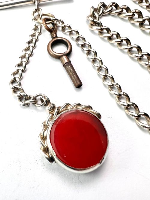 fig 1. A Victorian sterling silver curb link Albert watch chain featuring a T-bar, watch key charm, and red stone swivel fob.