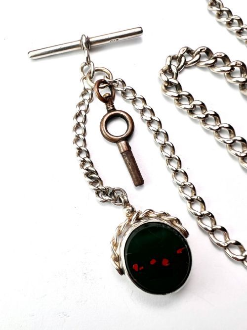 fig 2. A Victorian sterling silver curb link Albert watch chain featuring a T-bar, watch key charm, and red stone swivel fob.