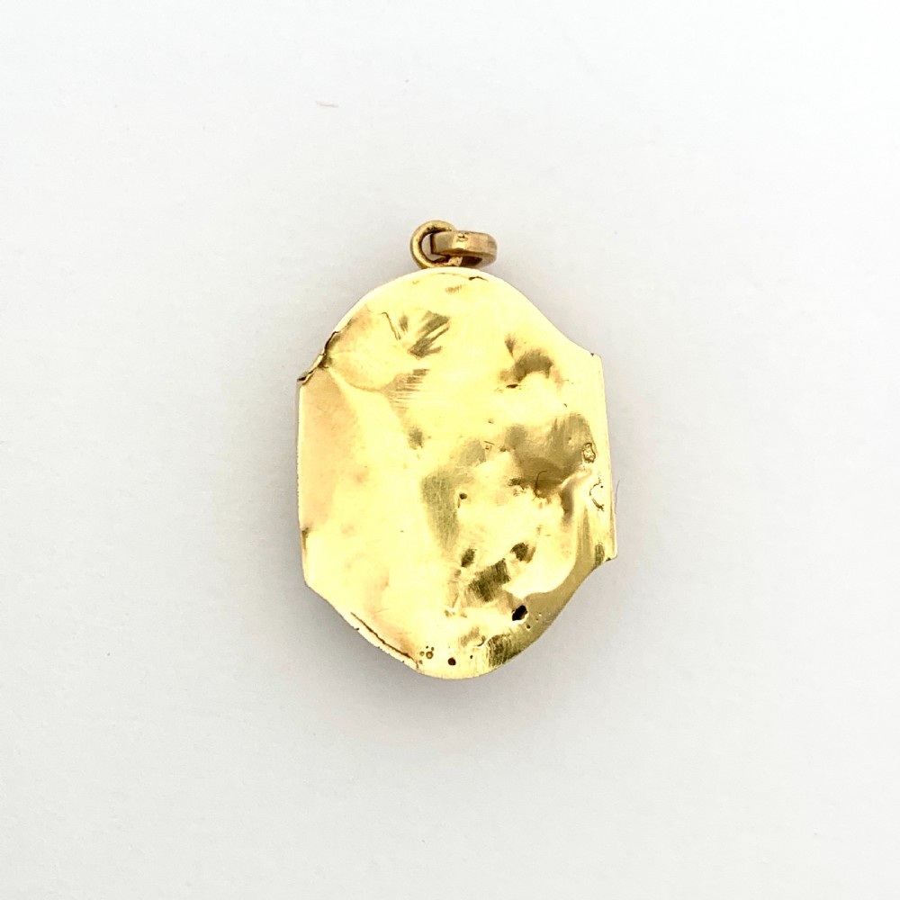 An oval Victorian 18ct gold pendant featuring an orange-red carved coral cameo classical bust framed by a beaded gold border. View IV