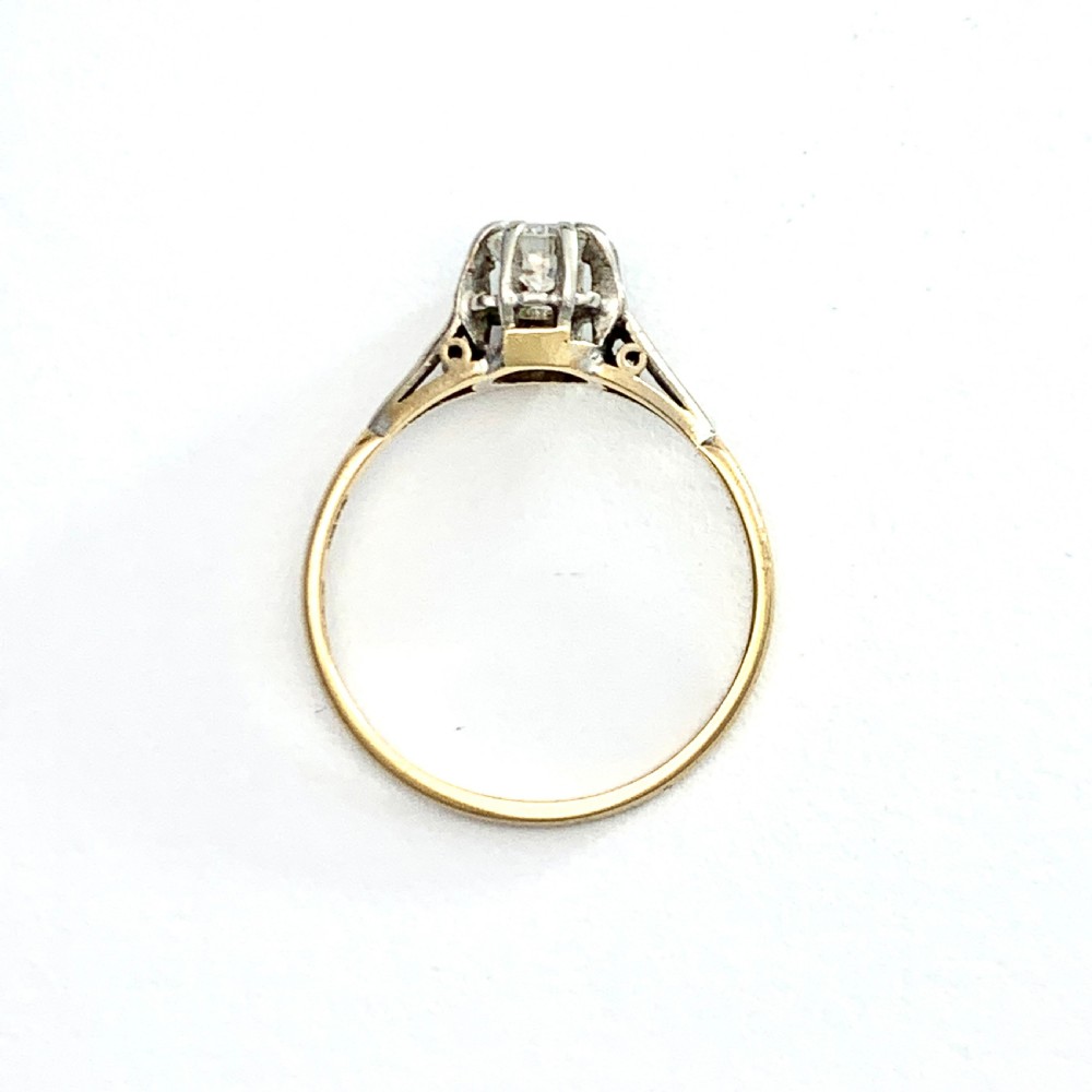 A vintage 18ct yellow gold solitaire ring displaying a single round diamond held in platinum claws with geometric shoulders. View III