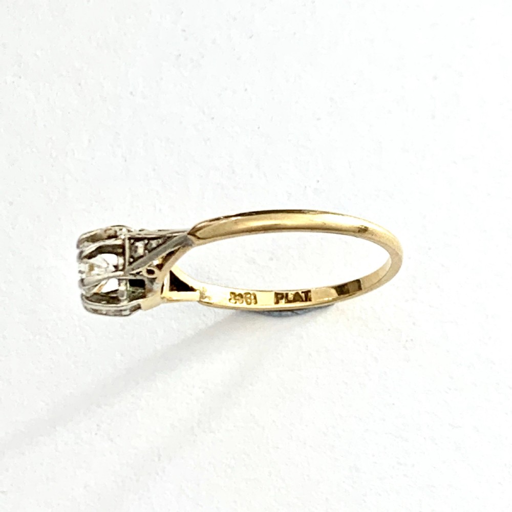 A vintage 18ct yellow gold solitaire ring displaying a single round diamond held in platinum claws with geometric shoulders. View IV