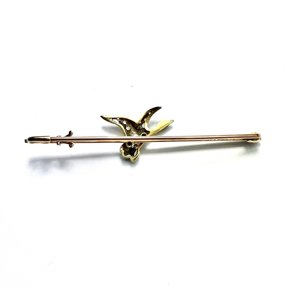 An Edwardian 15ct gold bar brooch featuring a flying duck set with diamonds and green enamel details. View III
