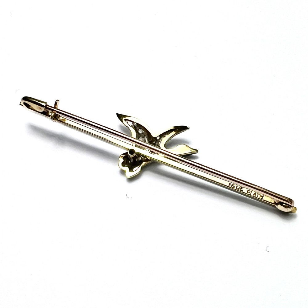 An Edwardian 15ct gold bar brooch featuring a flying duck set with diamonds and green enamel details. View V