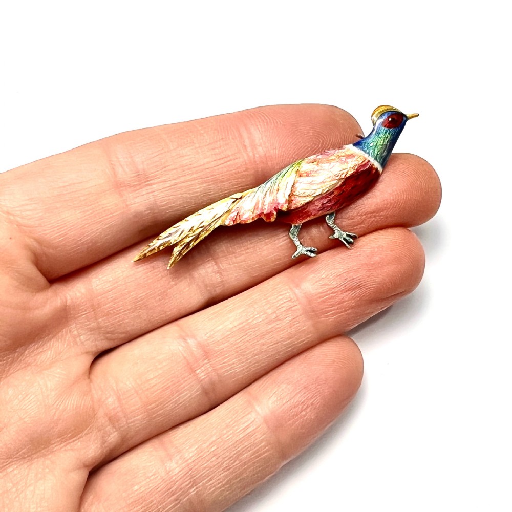 An Art Deco silver brooch shaped like a standing pheasant featuring red, green, blue, and gold enamel detailing. View II