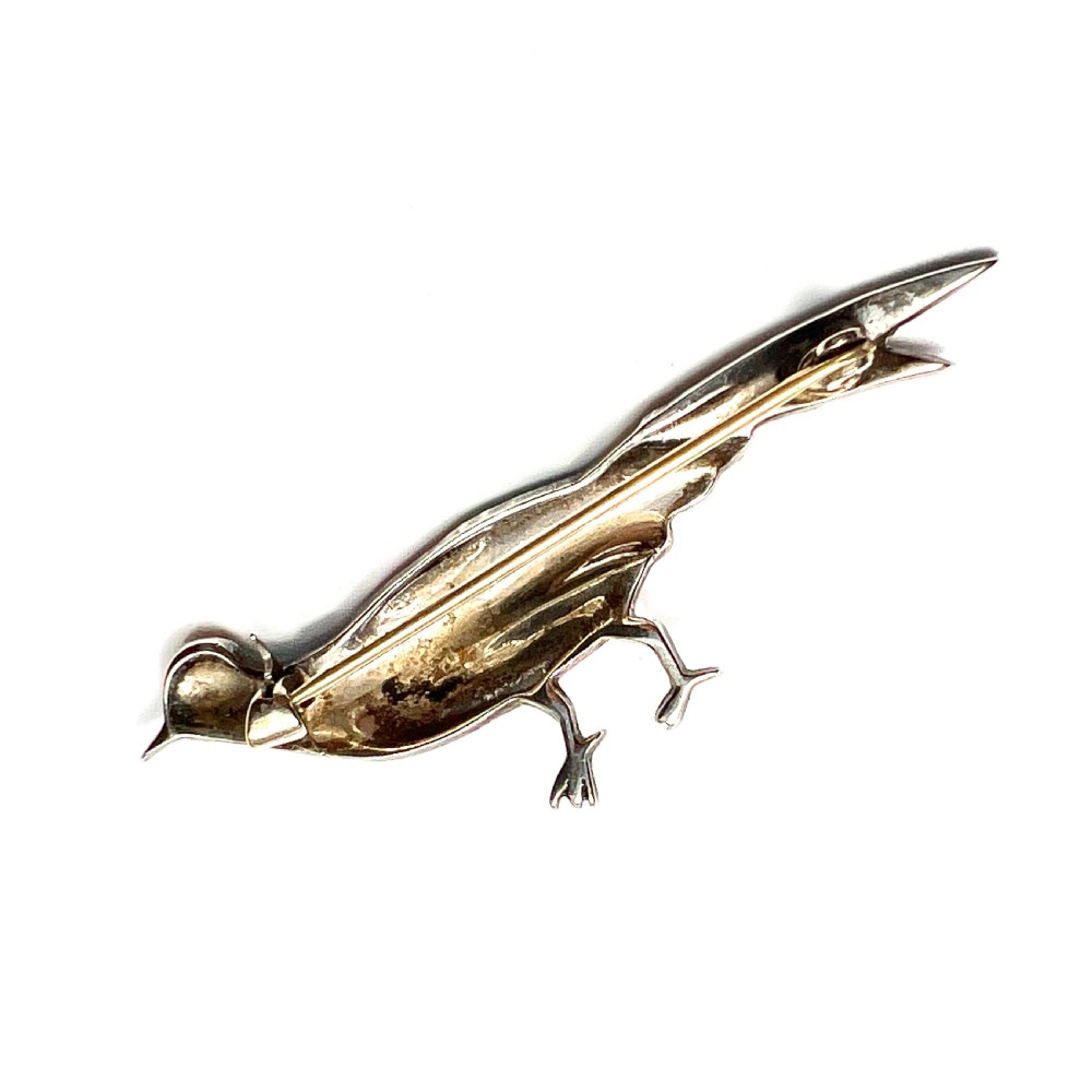An Art Deco silver brooch shaped like a standing pheasant featuring red, green, blue, and gold enamel detailing. View IV