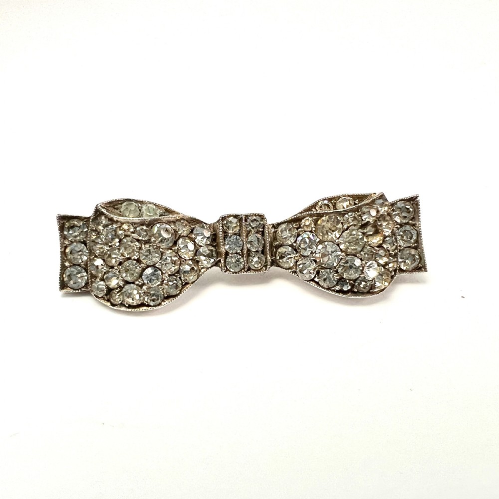 A vintage sterling silver bow brooch densely set with faceted clear paste stones. View II