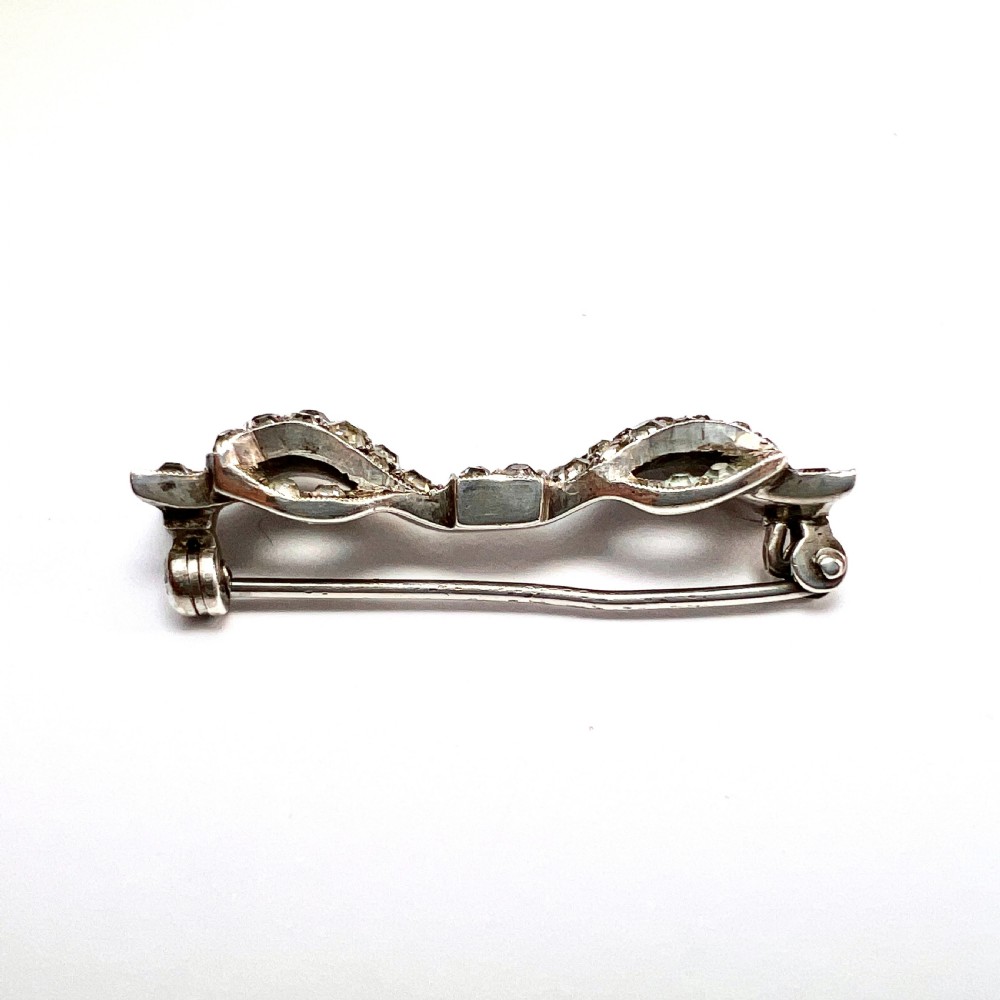 A vintage sterling silver bow brooch densely set with faceted clear paste stones. View III
