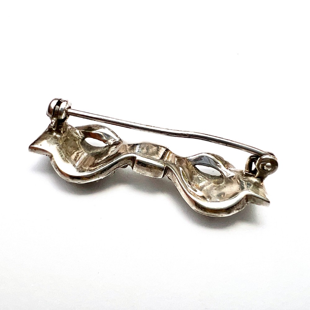 A vintage sterling silver bow brooch densely set with faceted clear paste stones. View IV