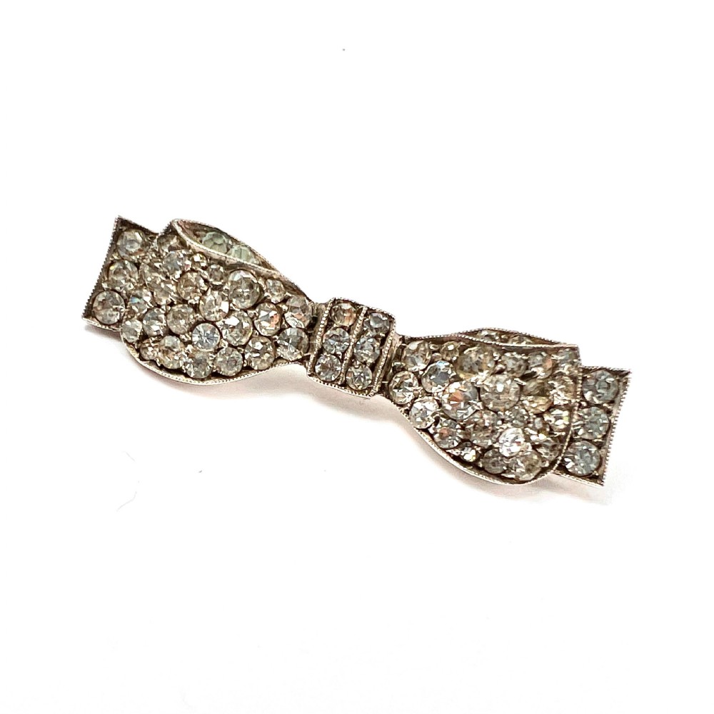 A vintage sterling silver bow brooch densely set with faceted clear paste stones. View V