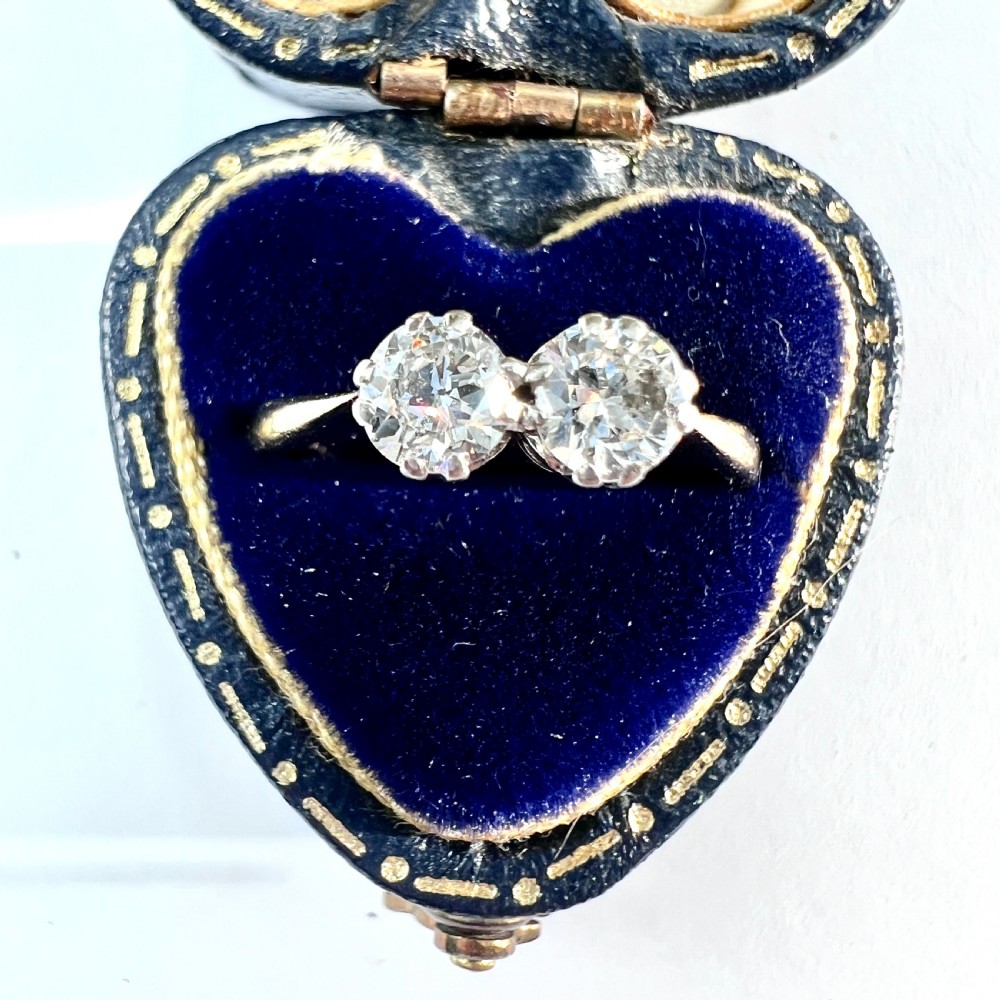 A vintage Toi et Moi ring featuring two round diamonds in platinum settings on an 18ct yellow gold band.