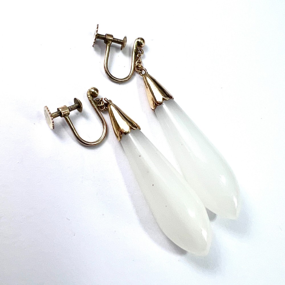 A pair of antique 9ct gold drop earrings featuring smooth, teardrop-shaped white chalcedony stones suspended on short chains from screw-back fastenings. View IV