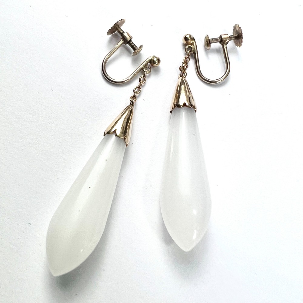 A pair of antique 9ct gold drop earrings featuring smooth, teardrop-shaped white chalcedony stones suspended on short chains from screw-back fastenings. View VIII