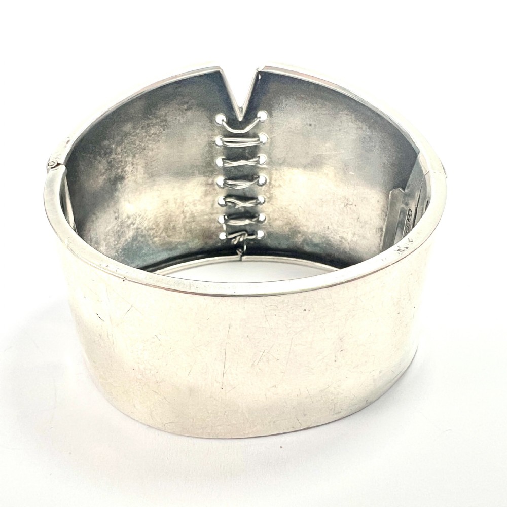 A wide sterling silver hinged cuff bangle featuring a corset-style laced centre detail flanked by intricate filigree borders. View III