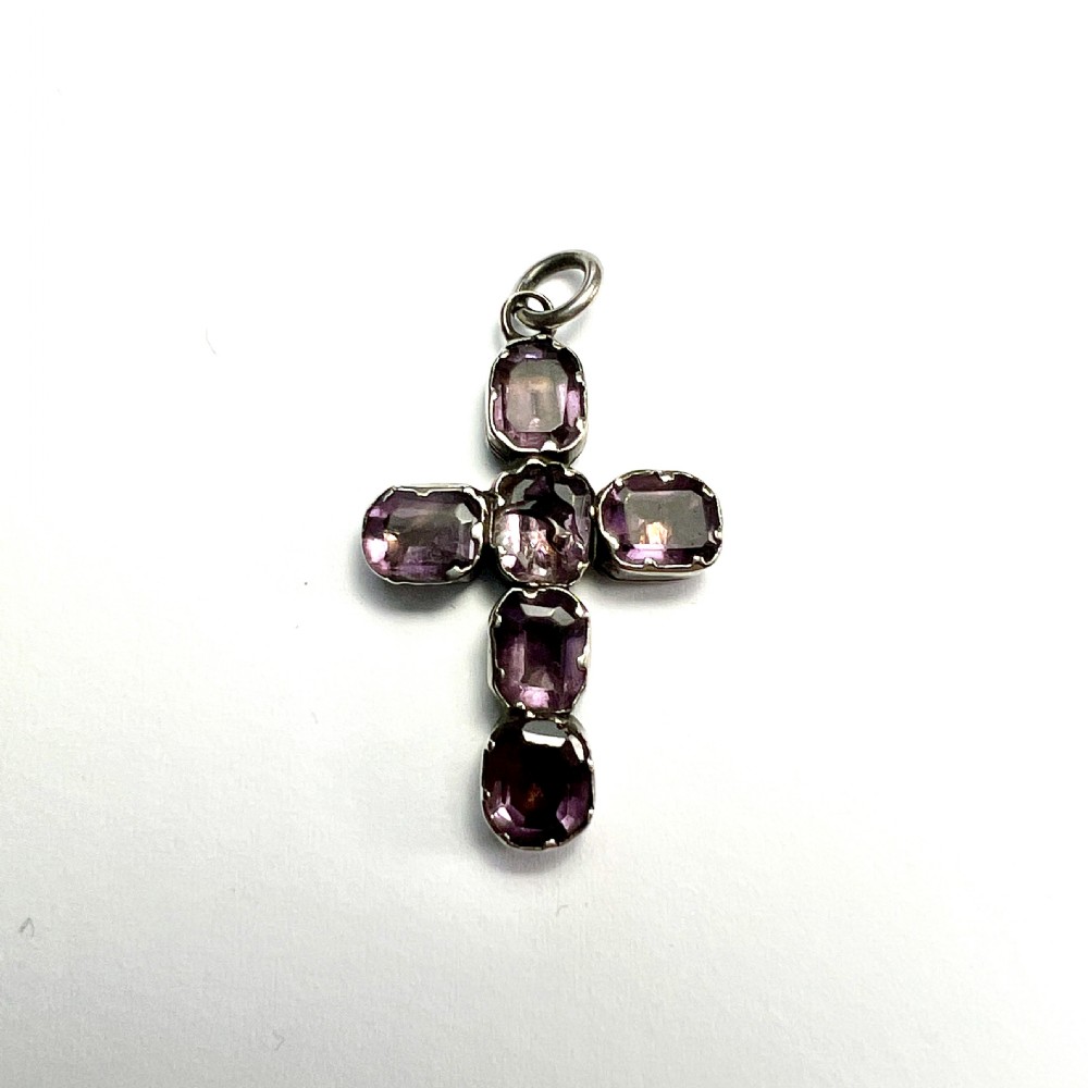 A Georgian silver cross pendant set with six foil-backed faceted purple amethyst gemstones in crimped collet settings.