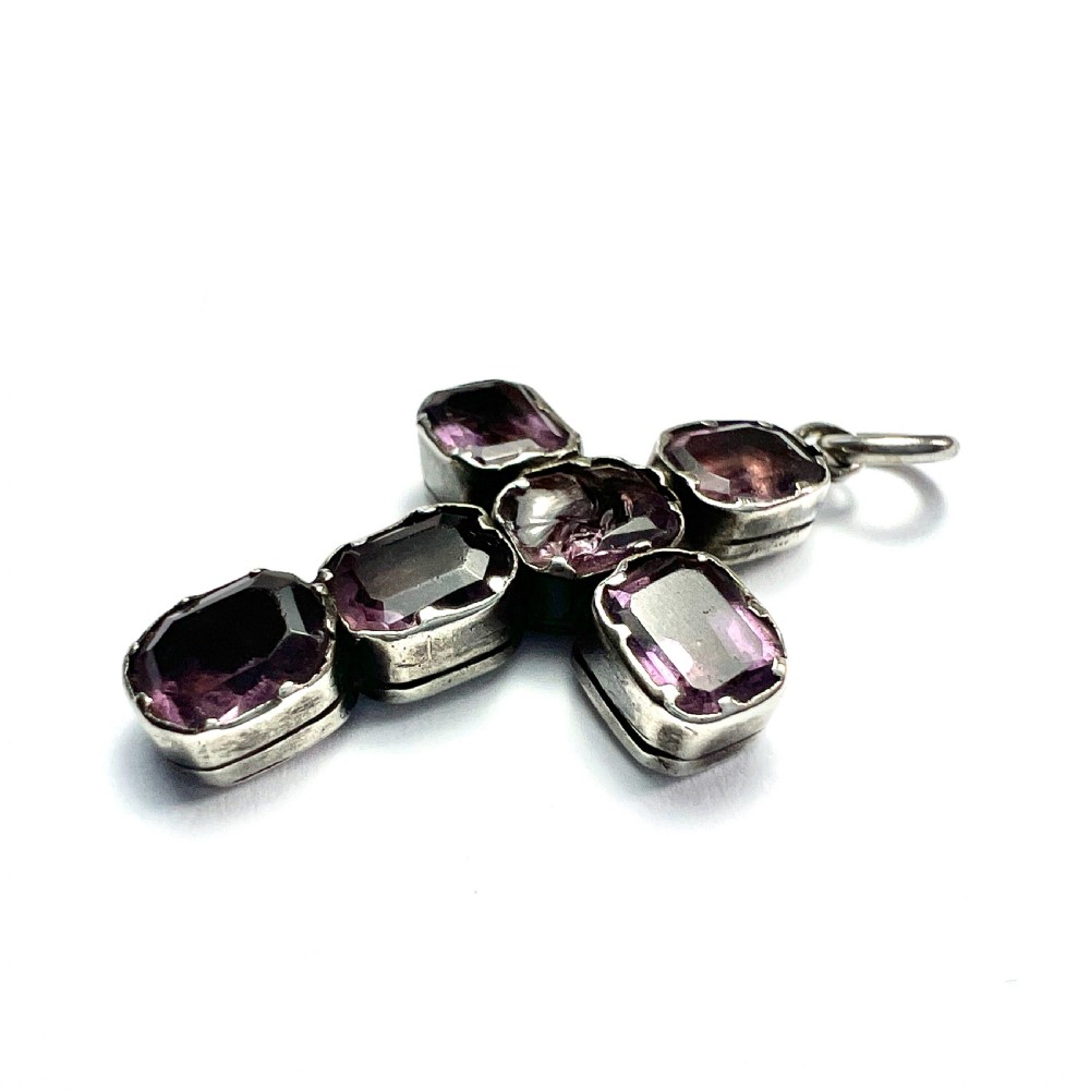 A Georgian silver cross pendant set with six foil-backed faceted purple amethyst gemstones in crimped collet settings. View V