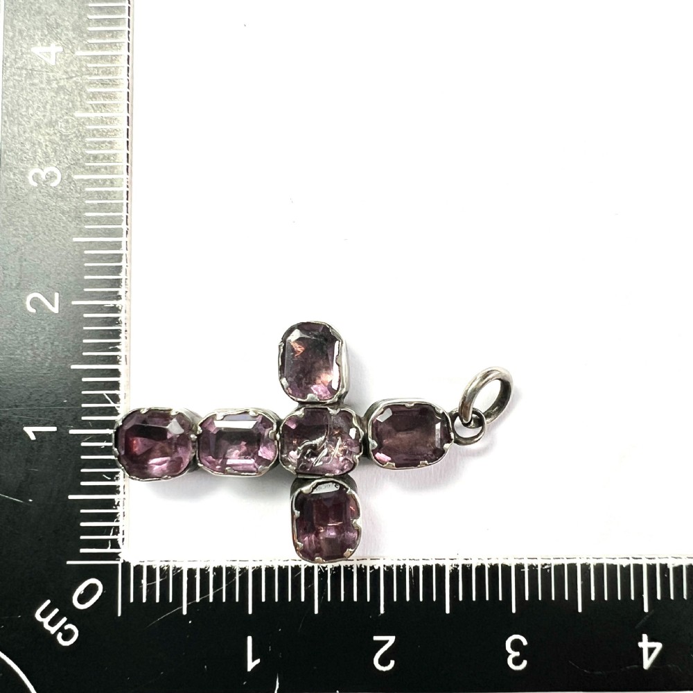 A Georgian silver cross pendant set with six foil-backed faceted purple amethyst gemstones in crimped collet settings. View VIII