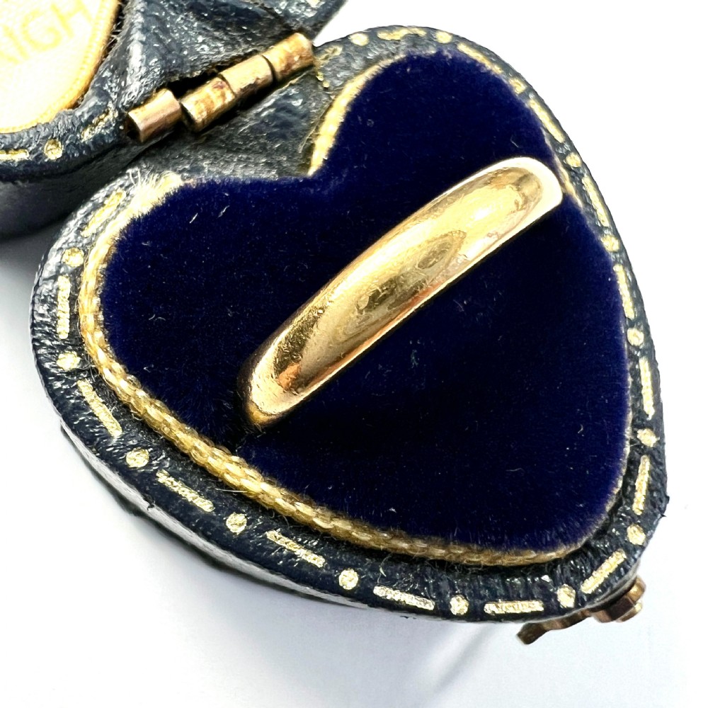 A polished 22ct yellow gold wedding band featuring a smooth, rounded profile. View IV