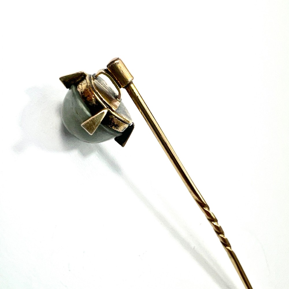 An antique 9ct gold stick pin featuring a central spherical green gemstone set with four small rose-cut diamonds, displayed inside an open velvet-lined leather jewellery box. View III