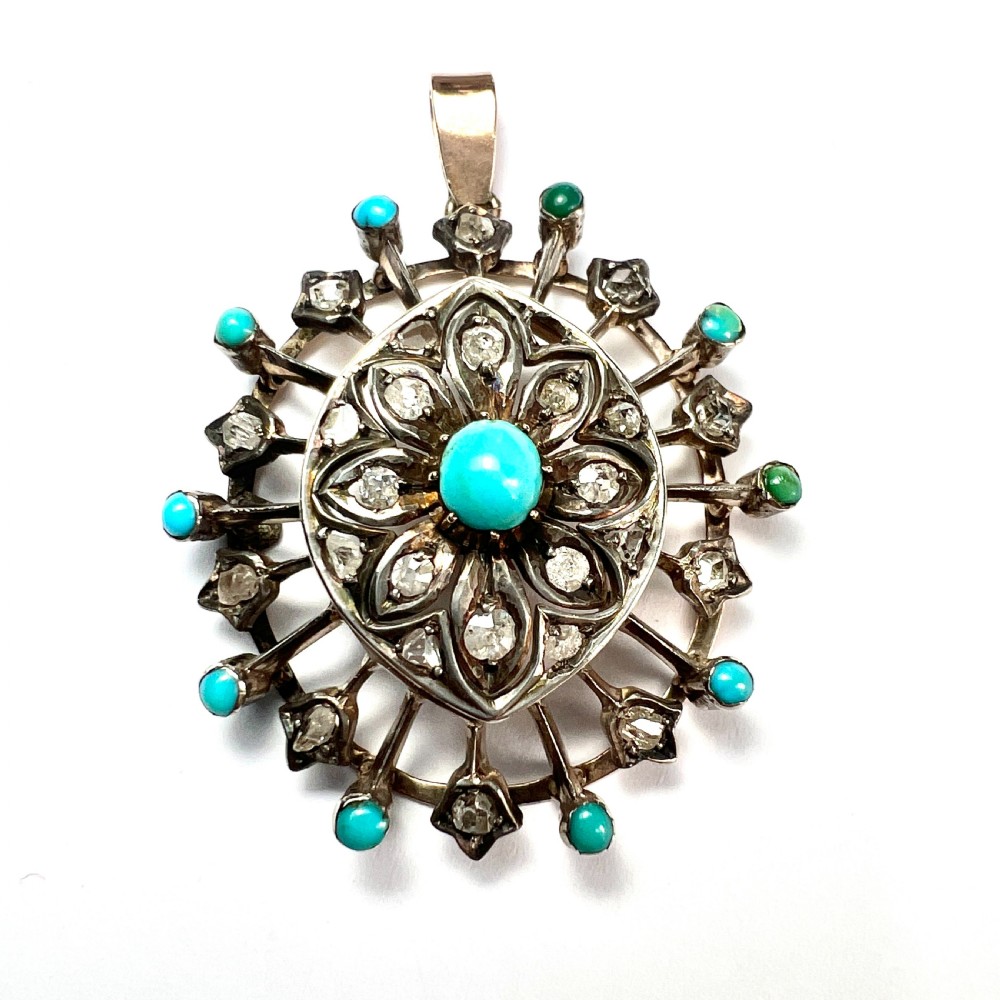 An antique circular pendant featuring a central turquoise cabochon framed by rose-cut diamonds and radiating turquoise-tipped spokes set in silver and gold.