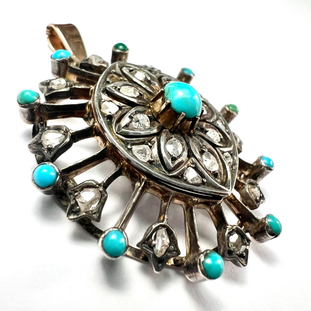 An antique circular pendant featuring a central turquoise cabochon framed by rose-cut diamonds and radiating turquoise-tipped spokes set in silver and gold. View III