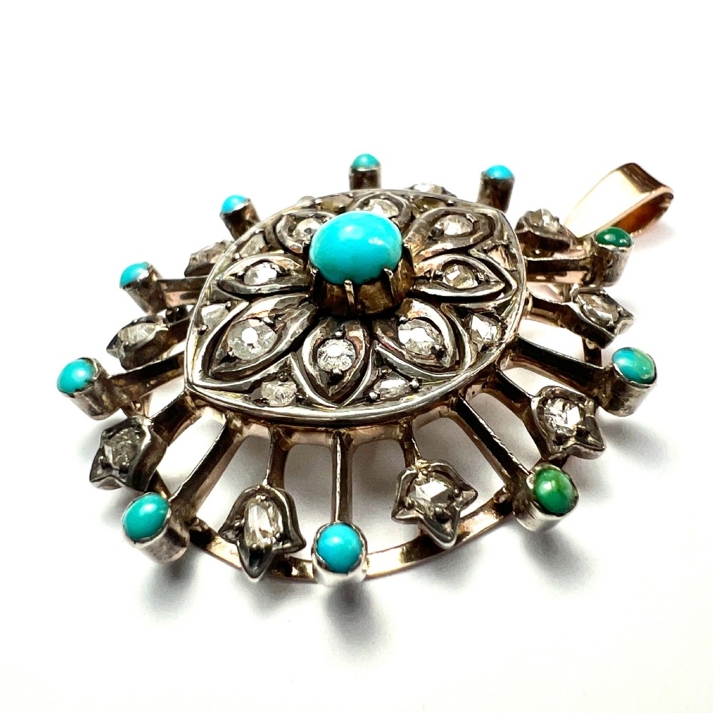 An antique circular pendant featuring a central turquoise cabochon framed by rose-cut diamonds and radiating turquoise-tipped spokes set in silver and gold. View IV