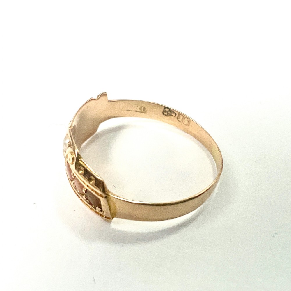 A Victorian 15 carat gold band ring set with rows of rounded seed pearls and pink coral cabochons featuring carved side scrollwork. View III