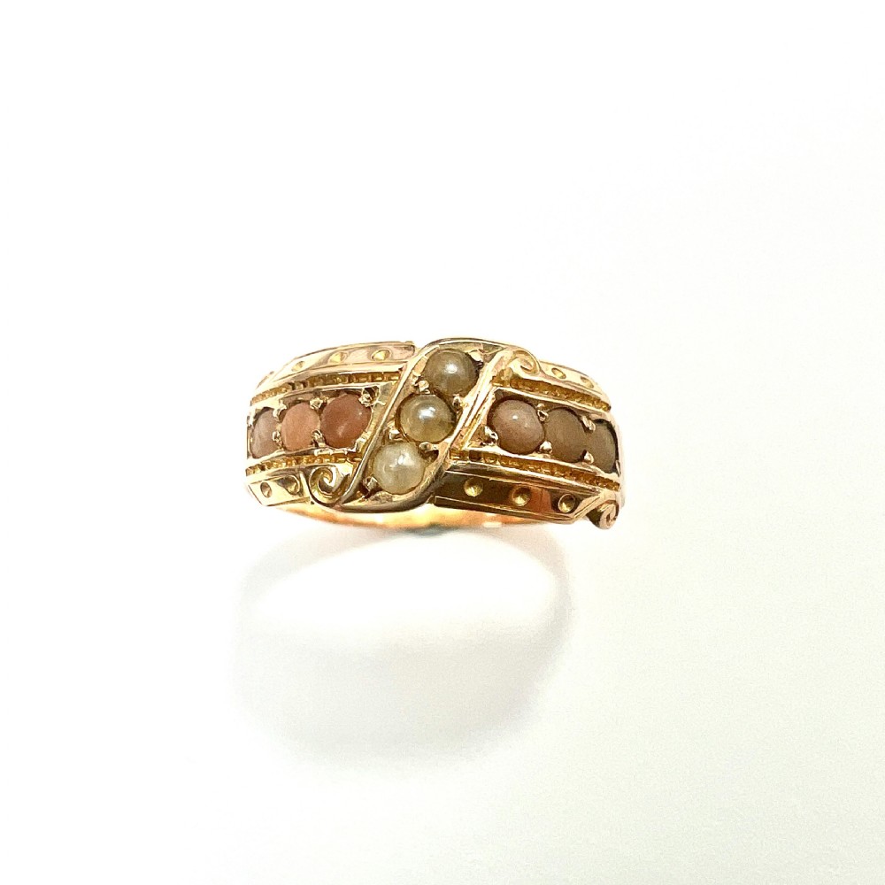 A Victorian 15 carat gold band ring set with rows of rounded seed pearls and pink coral cabochons featuring carved side scrollwork. View IV