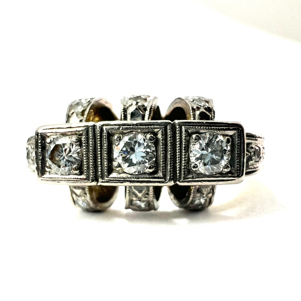 A vintage diamond engagement ring featuring three square-set diamonds in platinum and 14ct gold with geometric openwork detailing. View II