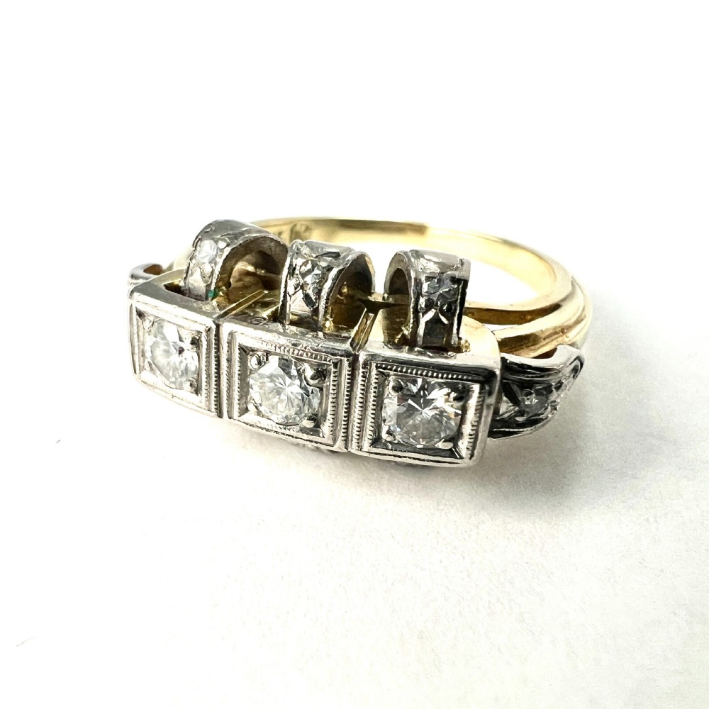 A vintage diamond engagement ring featuring three square-set diamonds in platinum and 14ct gold with geometric openwork detailing. View IV