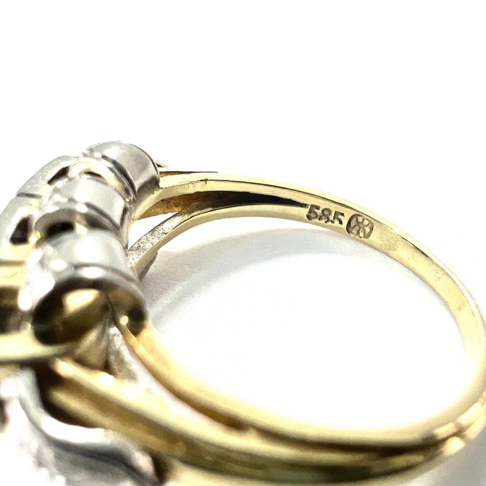 A vintage diamond engagement ring featuring three square-set diamonds in platinum and 14ct gold with geometric openwork detailing. View VII