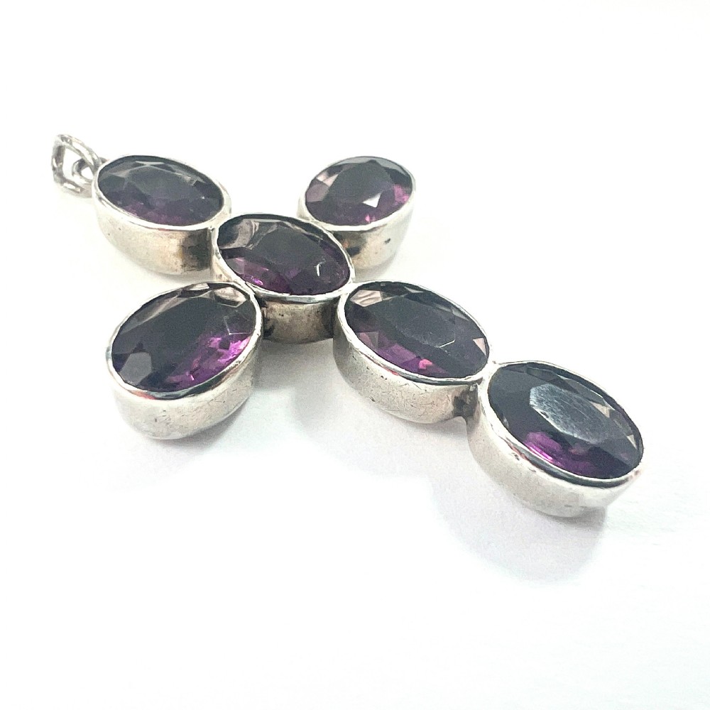 A Georgian silver cross pendant set with six oval faceted purple paste stones in closed collet mounts. View III