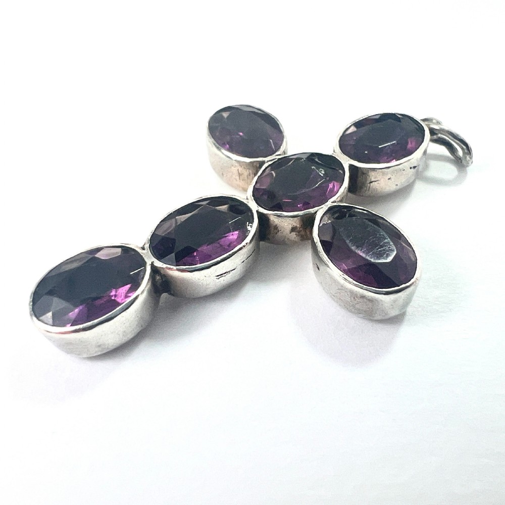 A Georgian silver cross pendant set with six oval faceted purple paste stones in closed collet mounts. View V