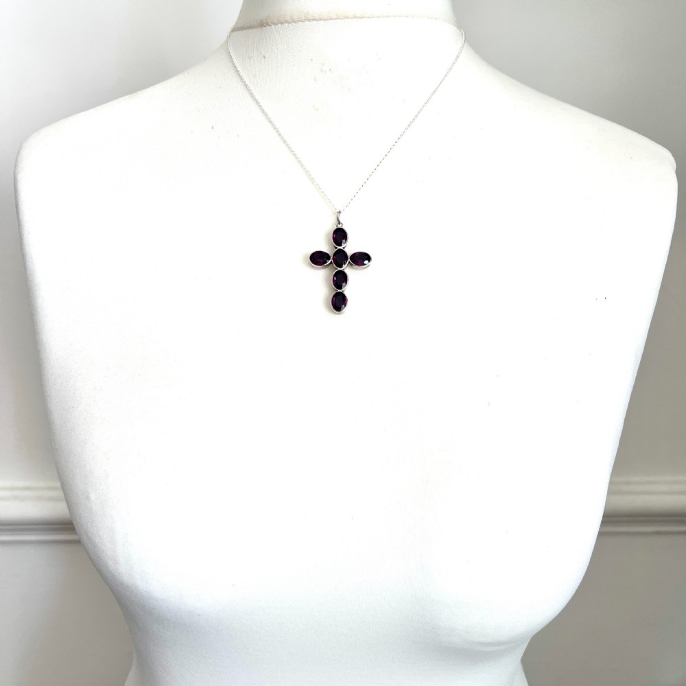 A Georgian silver cross pendant set with six oval faceted purple paste stones in closed collet mounts. View IX