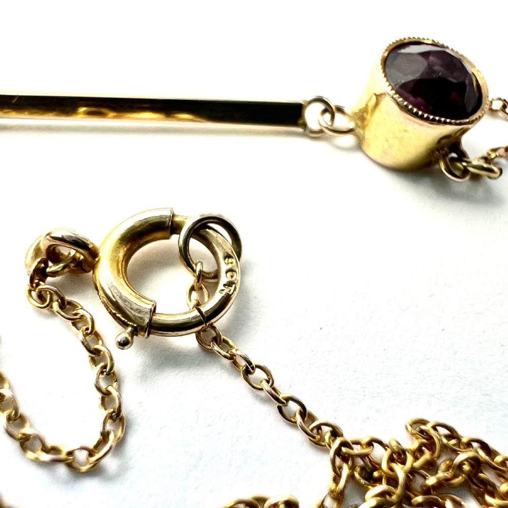 An Edwardian gold drop necklace featuring two round bezel-set purple amethyst stones connected by a slender gold bar on a fine chain. View VIII