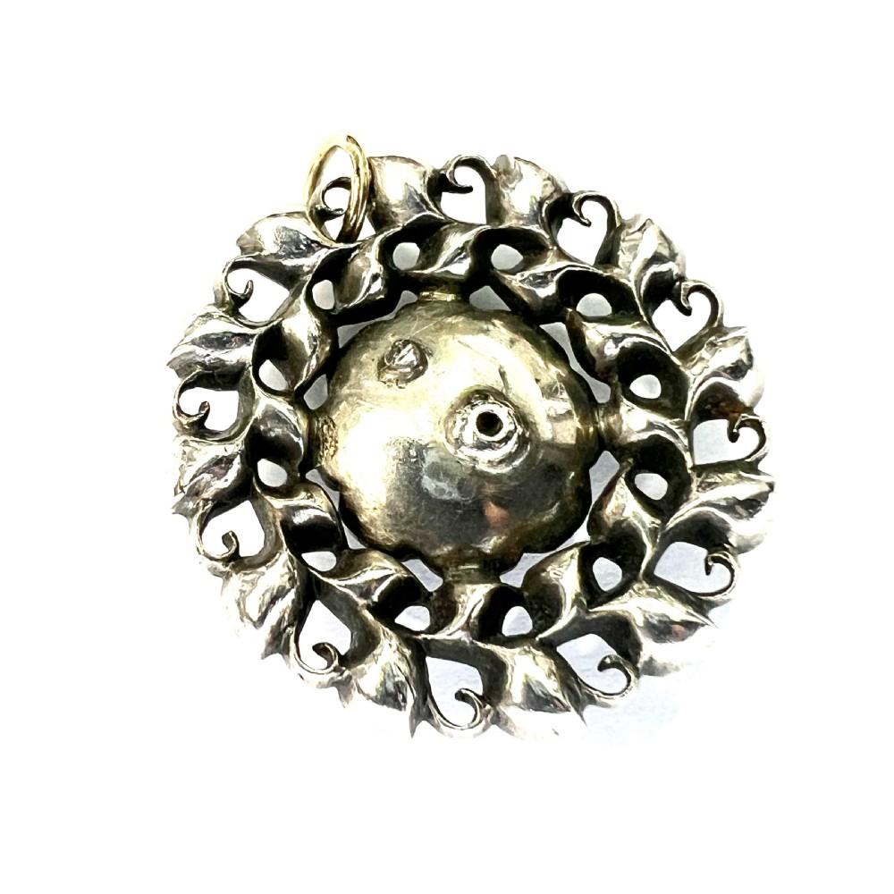 A circular Georgian silver pendant featuring faceted clear paste glass stones with black dot culets arranged in a floral cluster pattern. View III